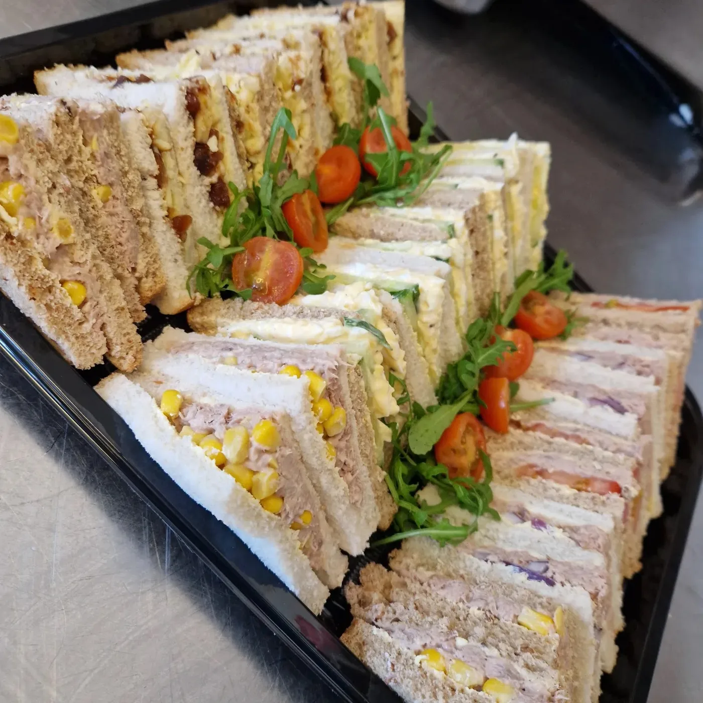 A platter of assorted triangle sandwiches